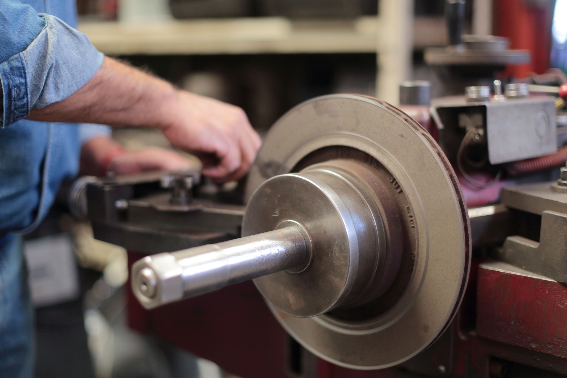 Mechanic adjusts lathe to grind brake disc